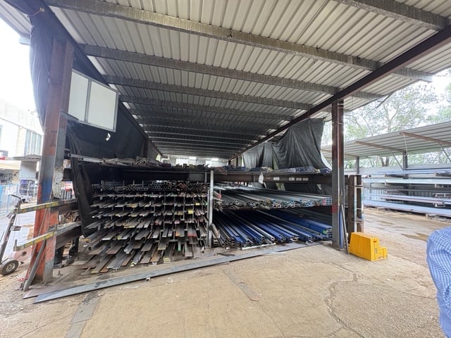 Long-length rack loaded with structural sections, purlins and pipe under cover