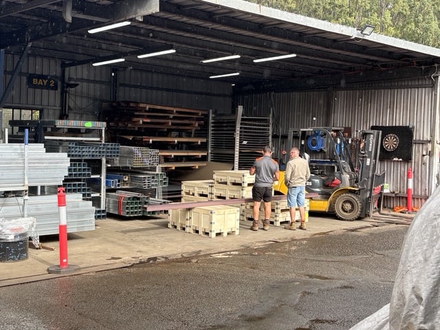 Bay 2 at the yard — team loading pallets beside the forklift