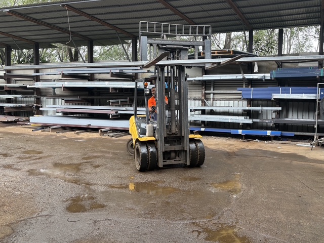 Pete on the forklift carrying steel across the yard