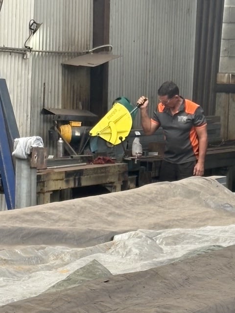 Worker at the cold-cut saw in the Marshall Steel workshop